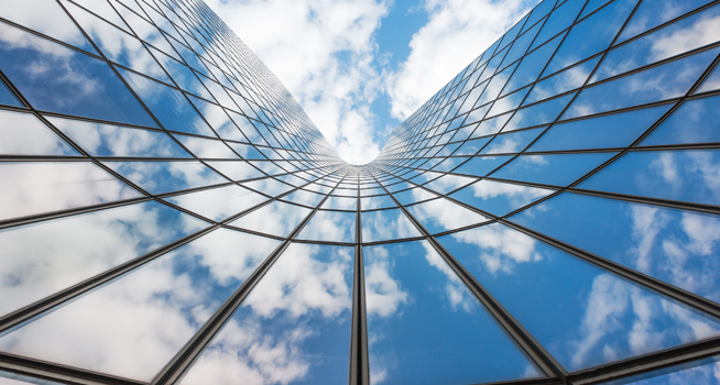 Blue sky and white clouds reflecting in a glass building